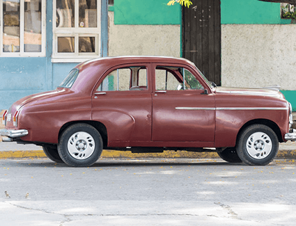 An old car sits on a street, ready to be stolen