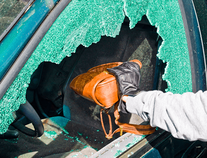 Thief grabbing a purse through a smashed window