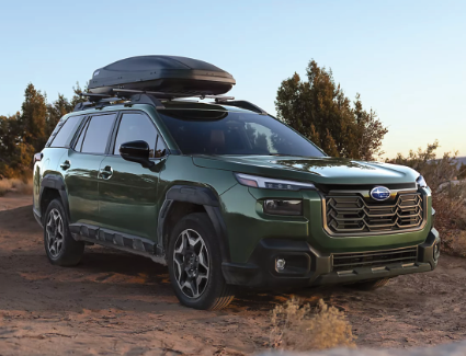Front angle view of a green 2026 Subaru Outback with cargo on the roof.