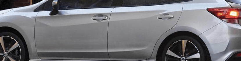 Photograph showcasing the door handles on a gray sedan.