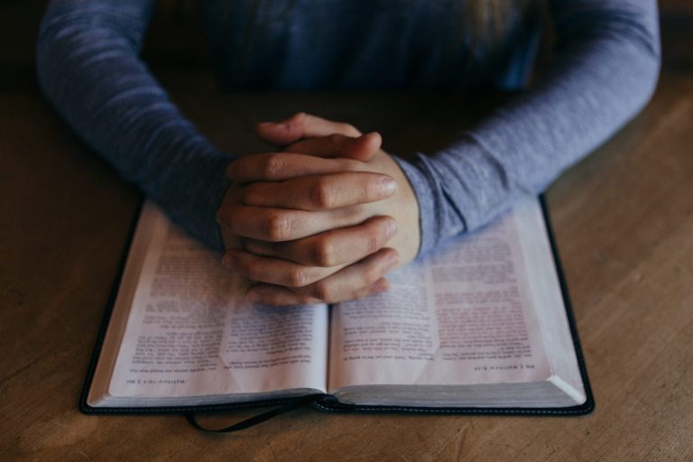 A believer praying with Bible in hand