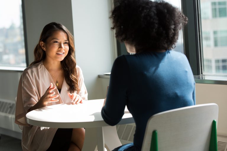 Two young women in the church having an animated conversation