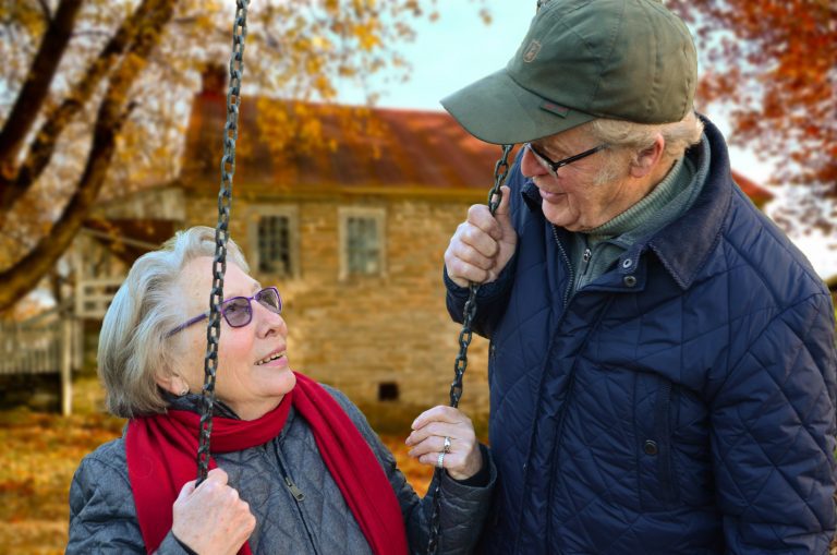 A distinguished senior missionary wife and husband engaged in animated conversation