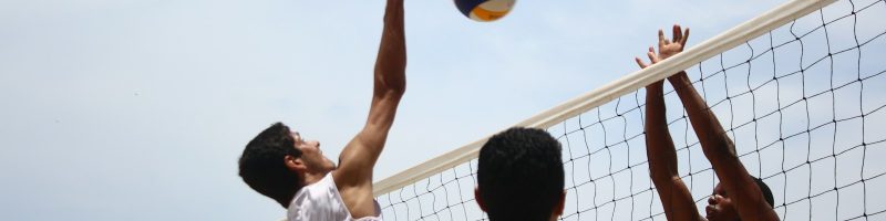 man in white shorts playing volleyball during daytime