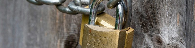 brown padlock on brown wooden fence
