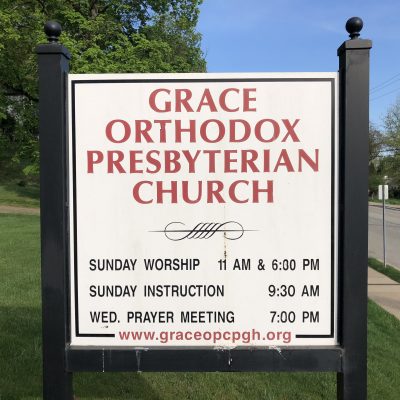 Grace Orthodox Presbyterian Church sign listing Sunday worship, instruction and prayer meeting times