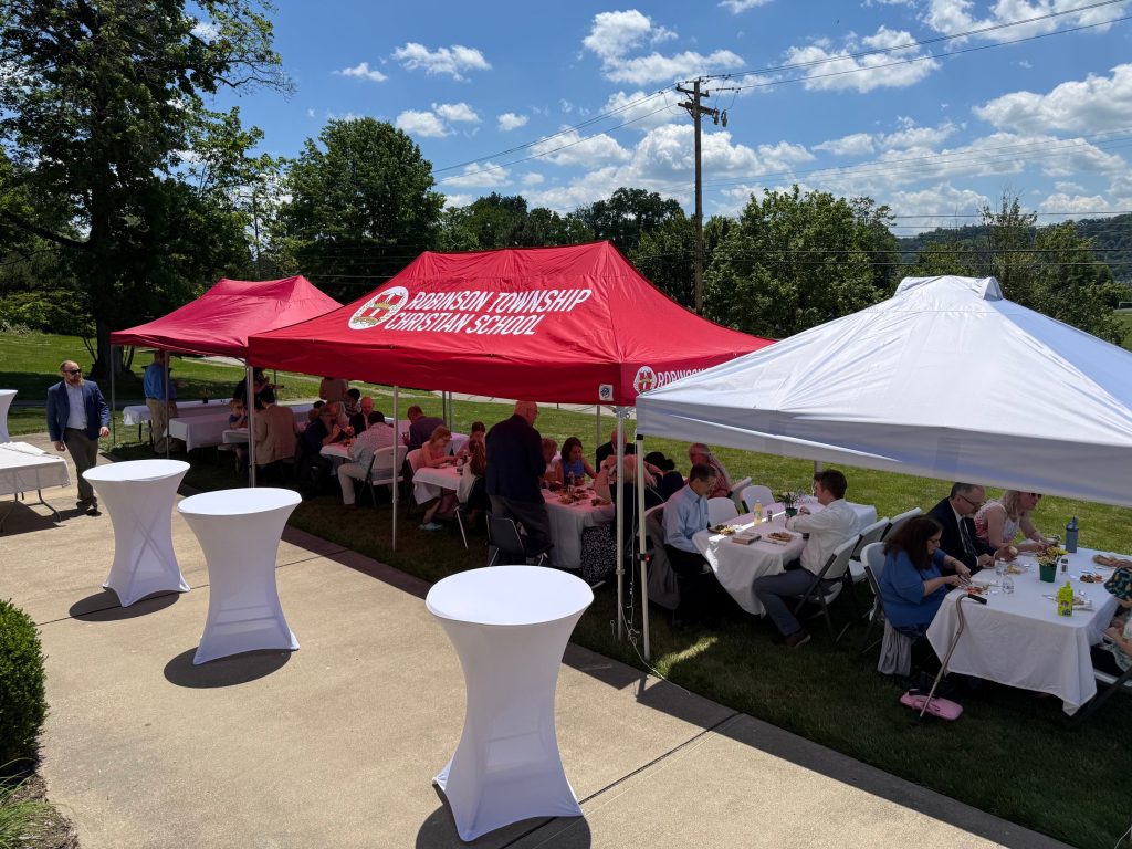Outdoor fellowship meal under tents on the lawn beside Grace OPC