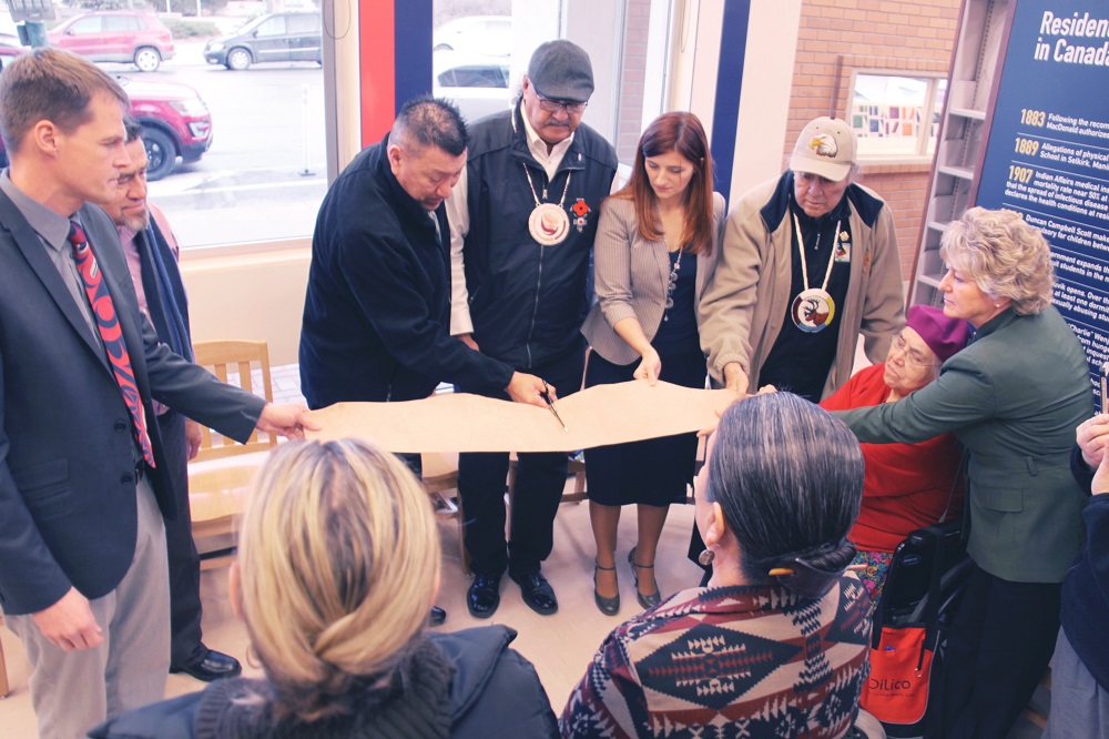 Hide Cutting at opening of SPL's Reconciliation Reading Area (l-r): Saskatoon Mayor Charlie Clark, Office of the Treaty Commissioner, Executive Director Harry Lafond, Kelly Bitternose (survivor), Eugene Arcand, SPL Board Chair Candice Grant, Elder Walter Linklater, Elder Maria Linklater and Carol Cooley CEO and Director of Libraries for Saskatoon Public Library. Photo credit: Eagle Feather News