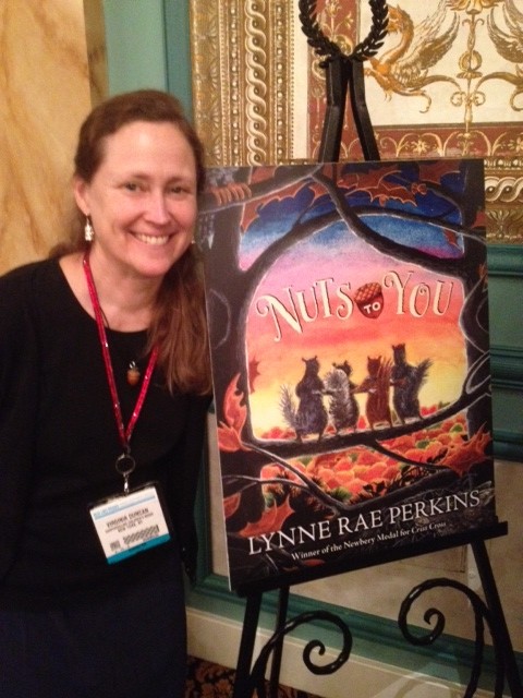 At the HarperCollins breakfast, editor Virginia Duncan posed with the cover of author Lynne Rae Perkins's latest book. Photo by Luann Toth.