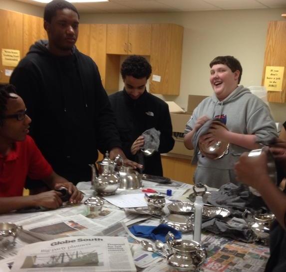 Victorian_Students investigate artifacts including hoop skirts, a washboard, and a bootjack.