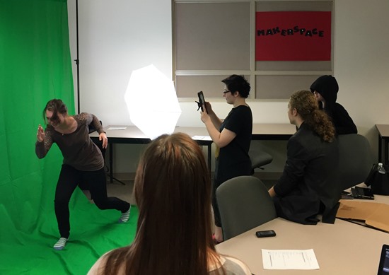 Teens at the xxxx record a scene for The Hunger Games book trailer using a makeshift green screen at their library's maker space.