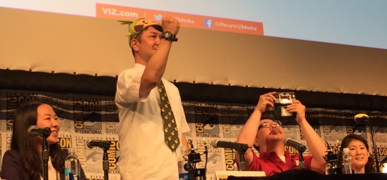 Pokemon writer Hidenori Kusaka plays Rock Paper Scissor with the audience while artist Satoshi Yamamoto takes a photo.