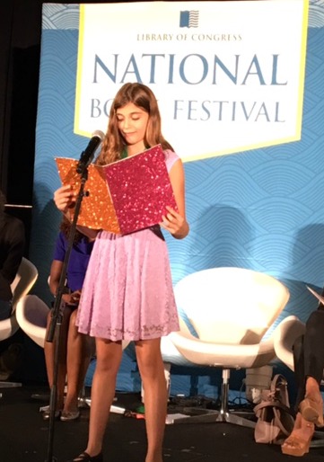 One of the young winners of the TK shares her letter with the audience.