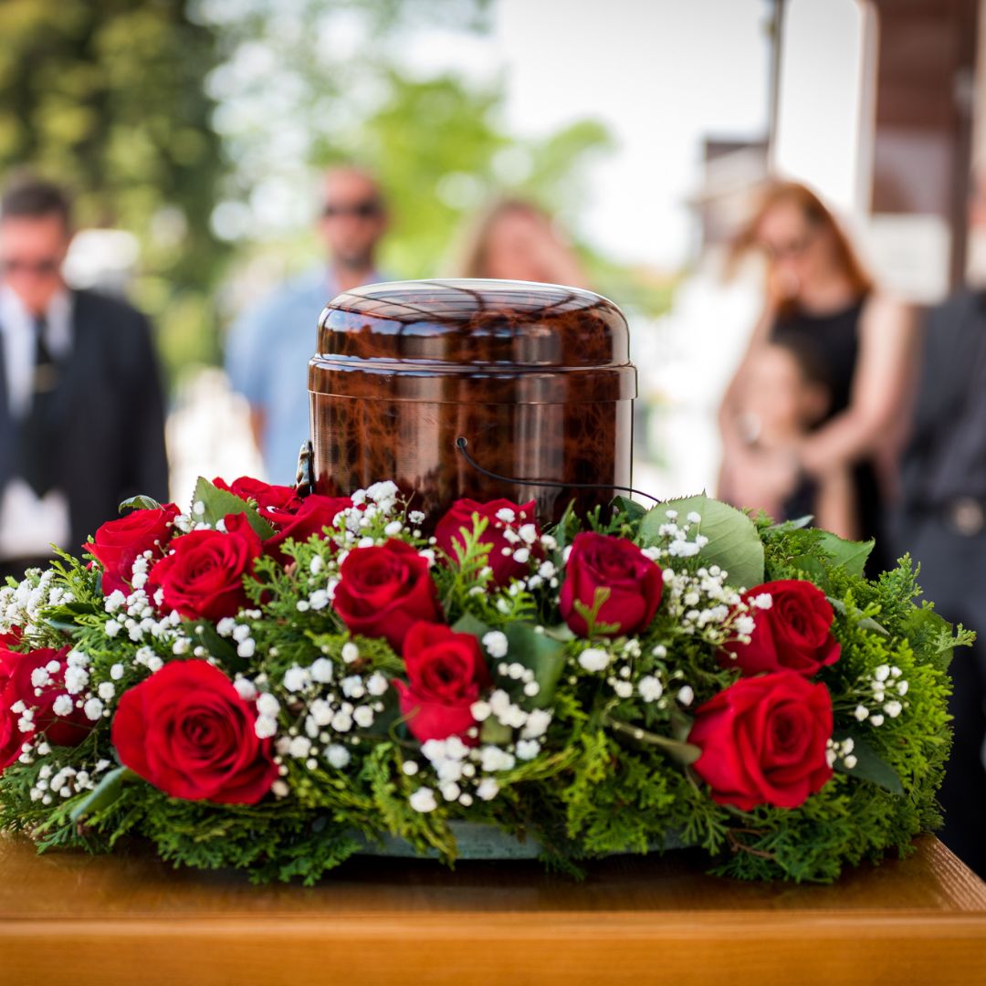 an urn surrounded by a wreath of roses