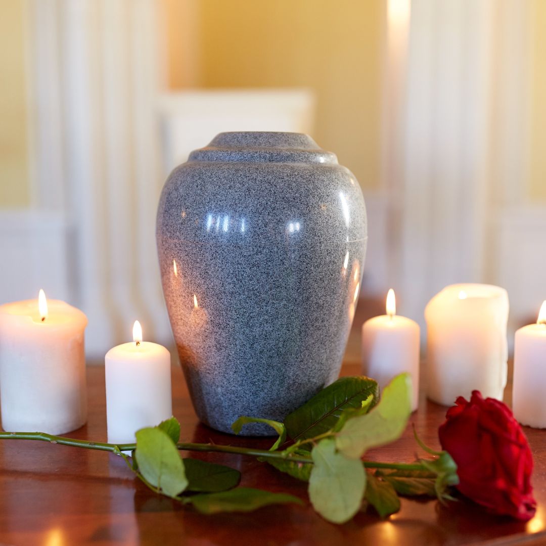 a stone urn with candles and roses