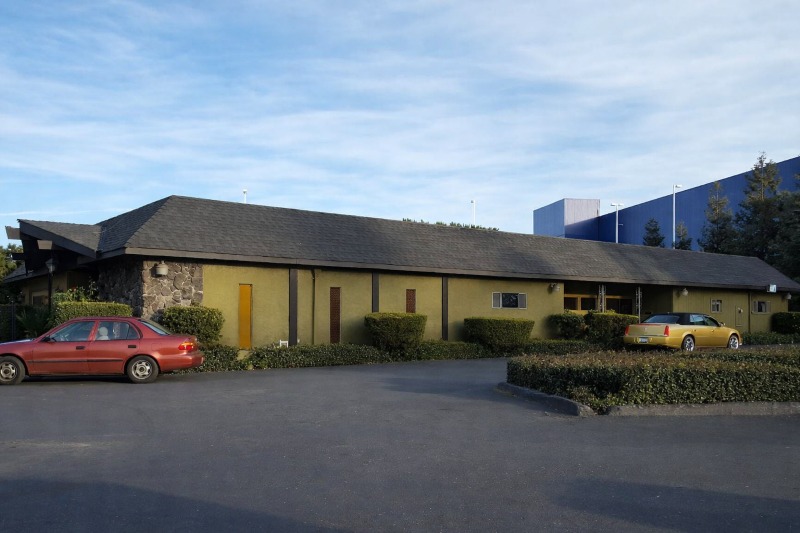 East Palo Alto, CA Funeral Home and Cremations exterior building with parking area and landscaped hedges