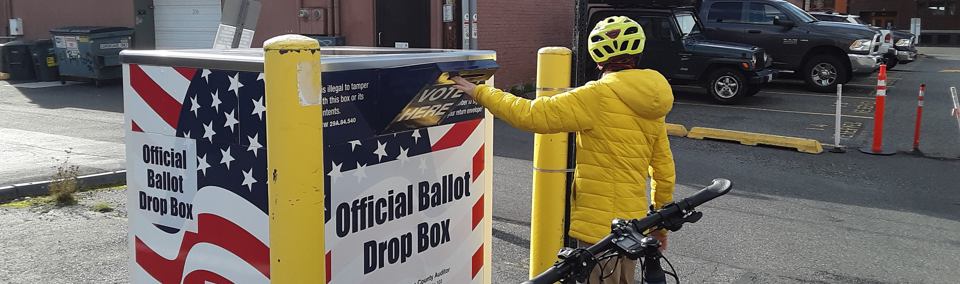 bicyclist voting at drop box