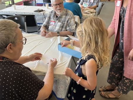 Girl handing out greeting cards at CHPV Lunch Gathering