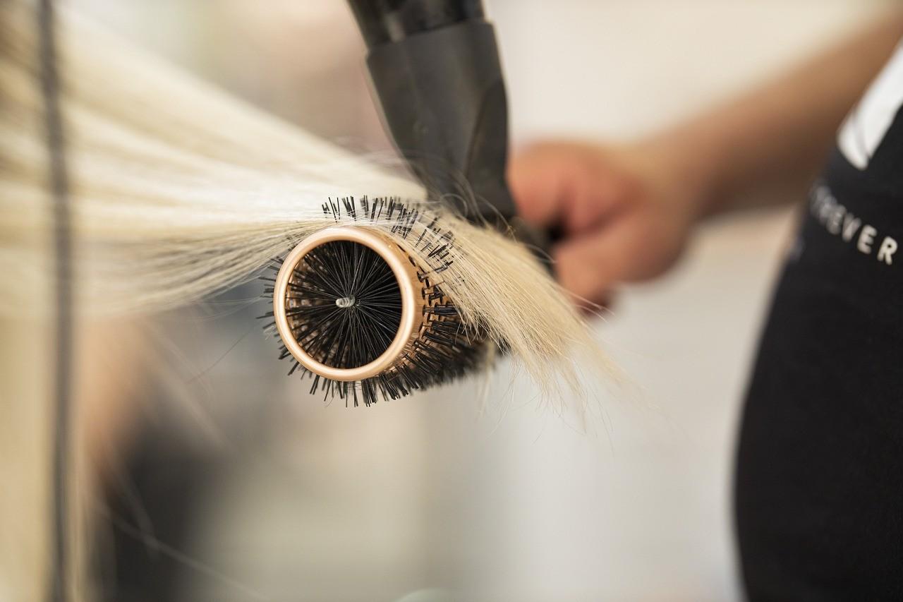 Profissional secando mecha de cabelo loiro descolorido
