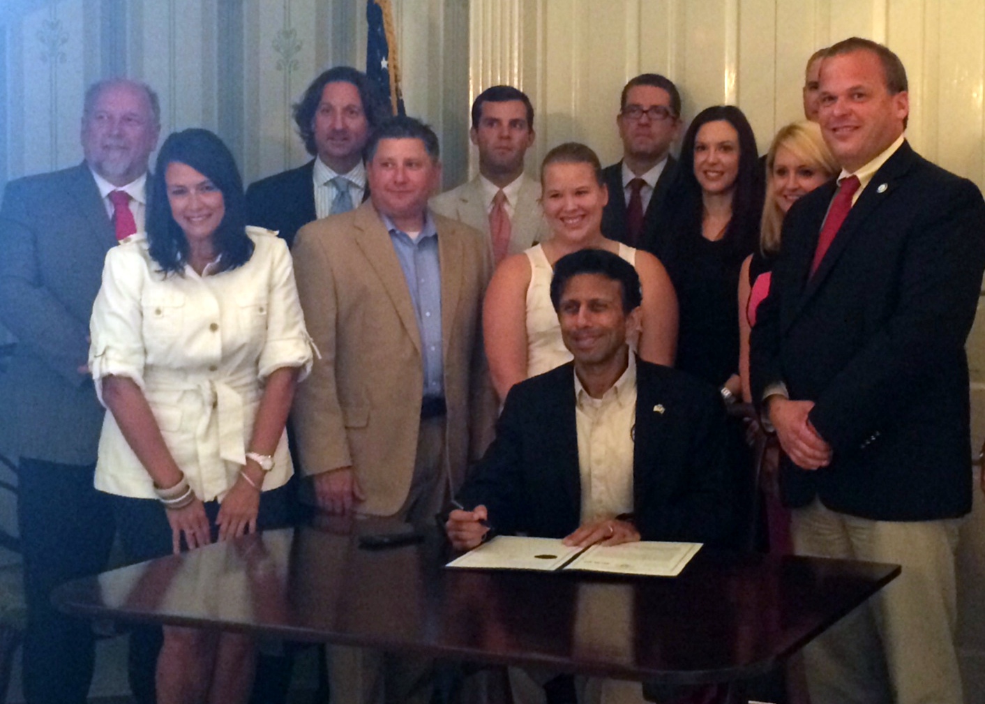 NFIB/Louisiana State Director Dawn Starns (in white) watches as Gov. Bobby Jindal signs a bill simplifying the state