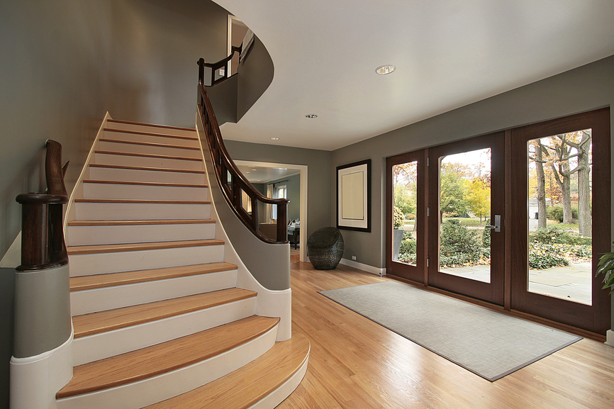 Contemporary foyer with light wood floor and straight stairs leading to landing.