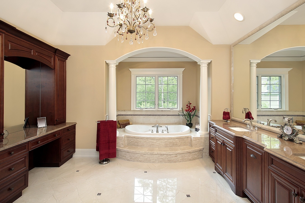 Bathroom in luxury home with bathtub nook and extensive custom dark wood cabinetry