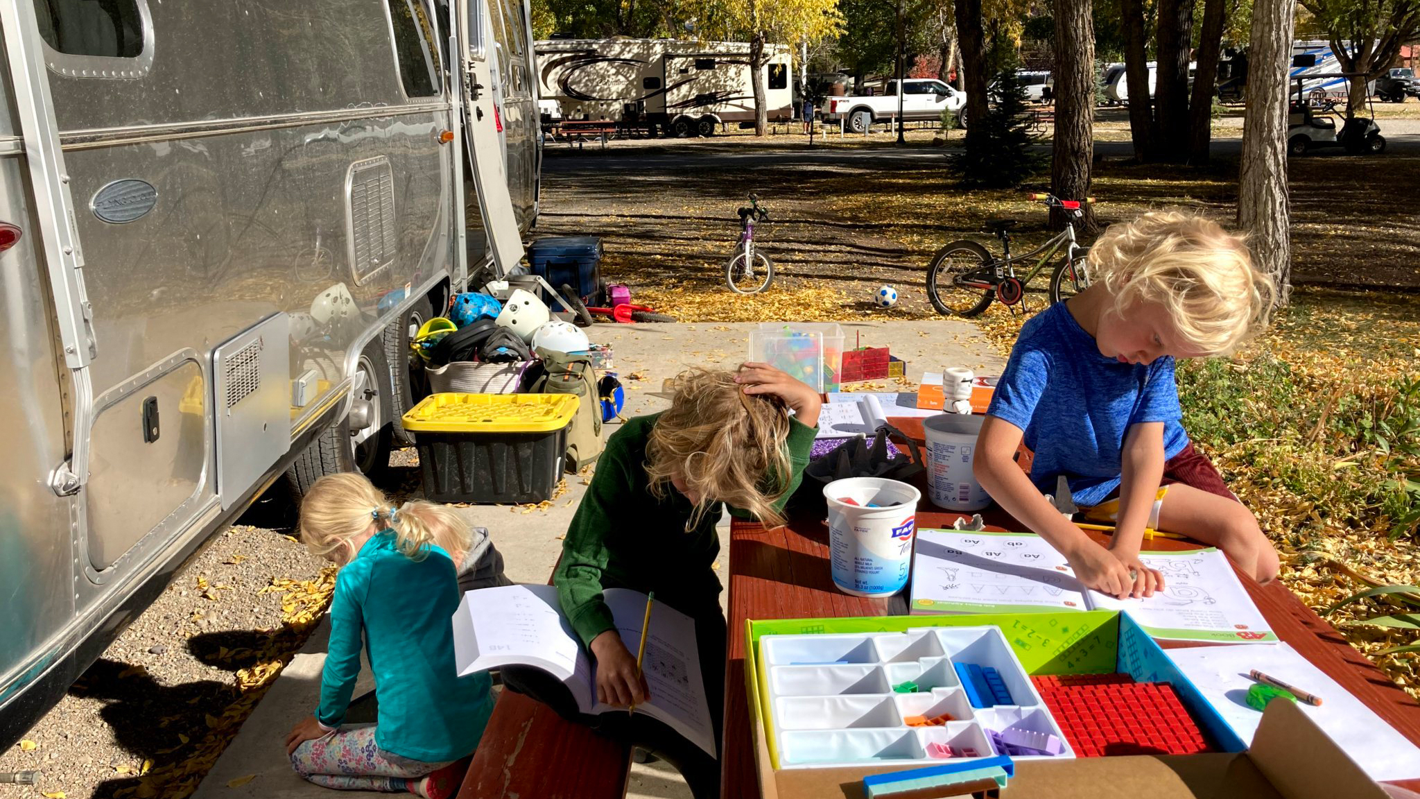 Kids sitting at a table outside of their Airstream travel trailer as they do school on the road.|Three kids sitting in a red hammock looking at their Airstream travel trailer that is parked in a woods.|Berries and snacks sitting on a piece of paper as a way to learn math|Feet standing on concrete next to five pieces of orange paper with numbers and dried flowers.|Nine pieces of colored paper with drawings from little kids.|Homeschooling-Grid-One|Homeschooling-Grid-Two|Homeschooling-Grid-Three|Kids sitting at a table outside of their Airstream travel trailer as they do school on the road.|Kids searching for crawdads in the woods.|Two kids looking at a map in their Airstream travel trailer while learning on the road.|Kids sitting at a table outside of their Airstream travel trailer as they do school on the road.