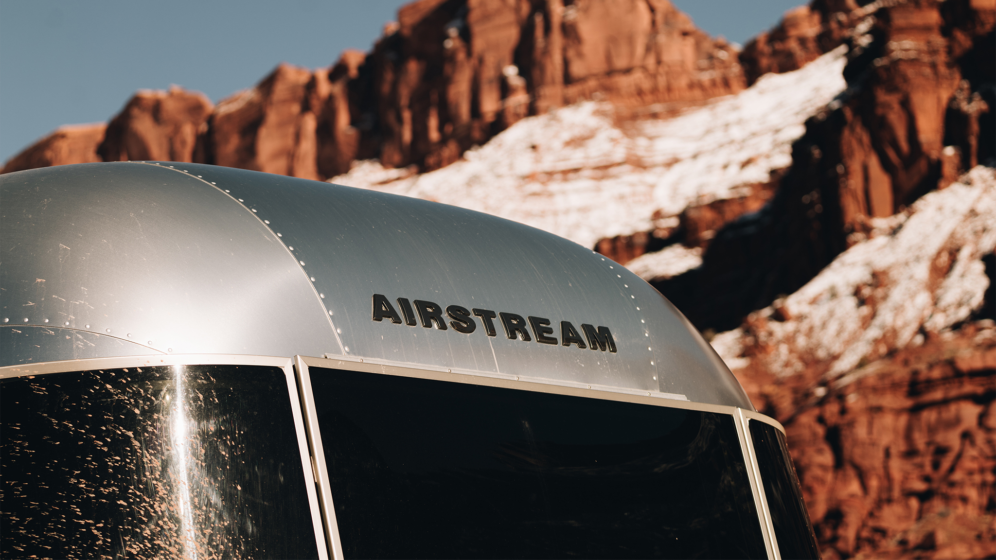 The top badge on an Airstream trailer|BambiCaravel-LP-SupportingAssets-V01-MobileHeader|Airstream-Flying-Cloud-Awning-feature|Airstream-Flying-Cloud-Front-Bunk-Optional-Feature|The top badge on an Airstream trailer