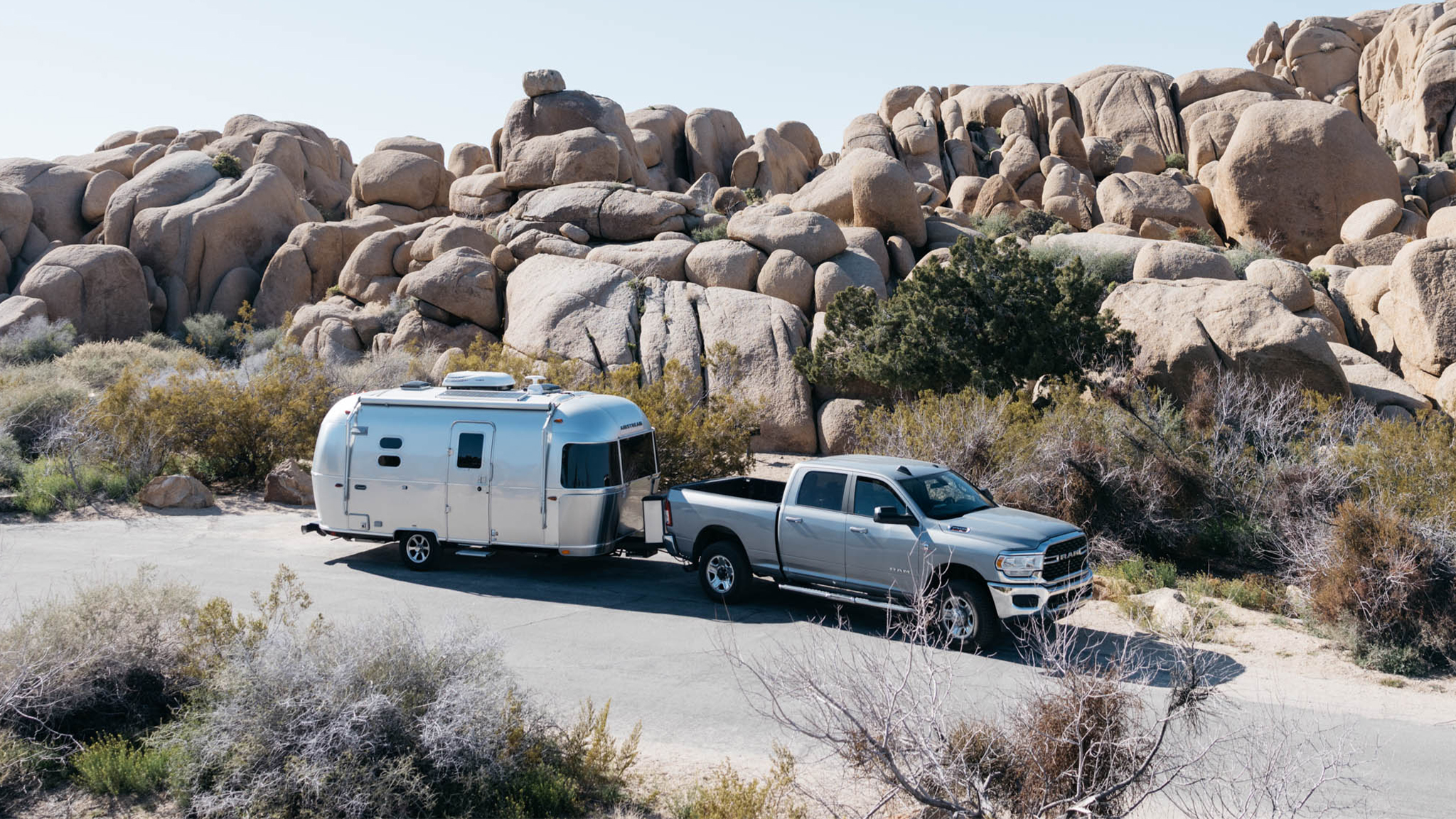 Surprising-Savings-Feature-Image|An Airstream caravel travel trailer being towed by a truck in the desert.