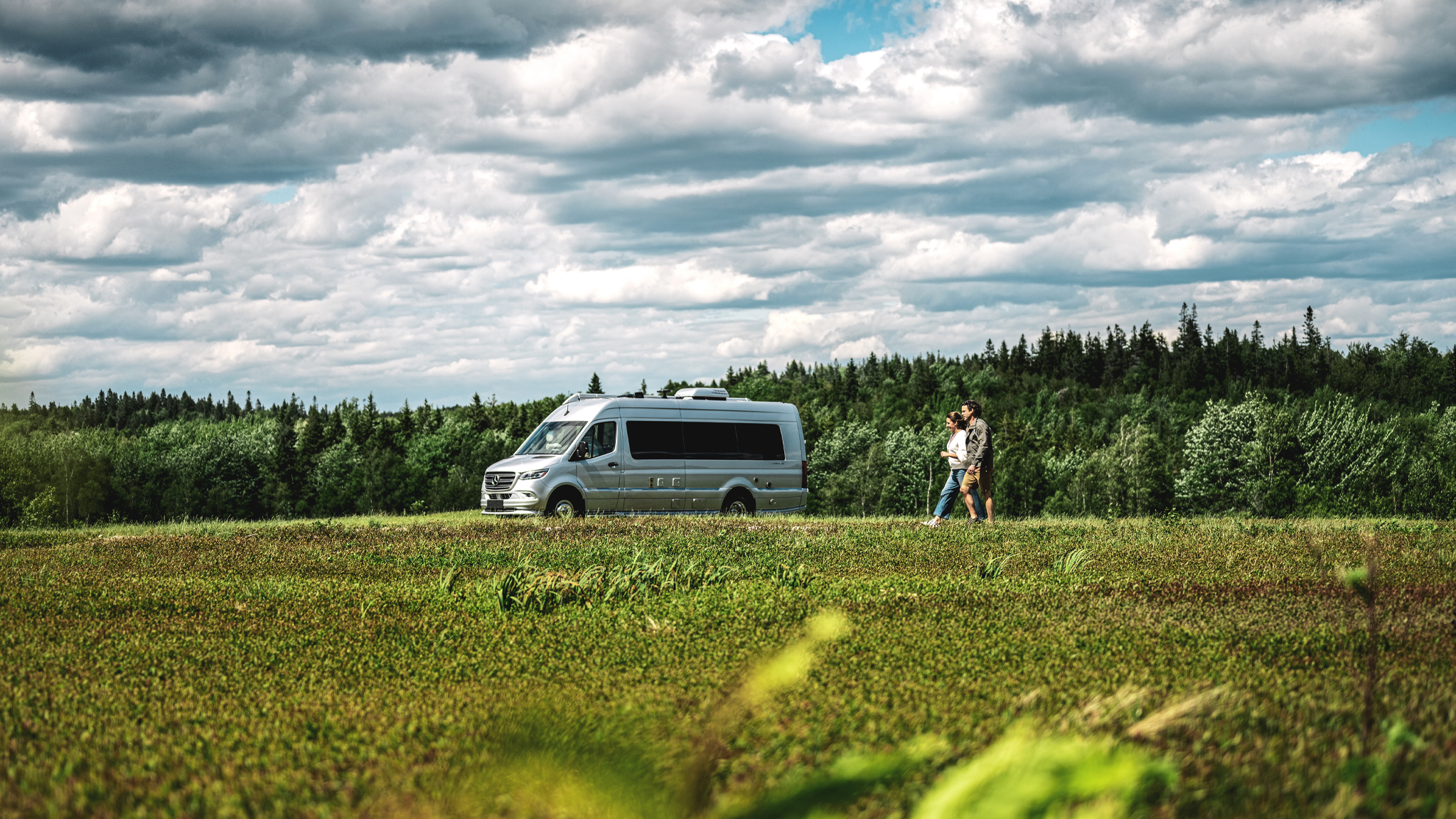Airstream Interstate Touring Coach parked in a field with a couple walking outside.|AIRMKT 2023 Interstate 19 Classic Canyon F2B PRINT|A group of Airstream workers standing next to the vintage Airstream A/Van|A vintage Airstream b-190 motorhome|Avenue-and-Park|Autobahn|Astrovan-II|AIRMKT-2019-Interstate-Slate-Interior-F2B_WEB|Interstate-24X-Lake|Airstream-Motorhome-History-Feature-Image|Airstream-Motorhome-History-Preview-Image