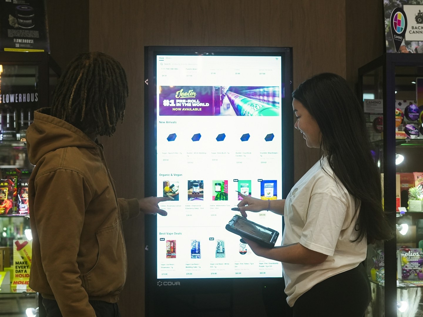 Interactive touchscreen kiosk with networked display showing product catalog in retail space