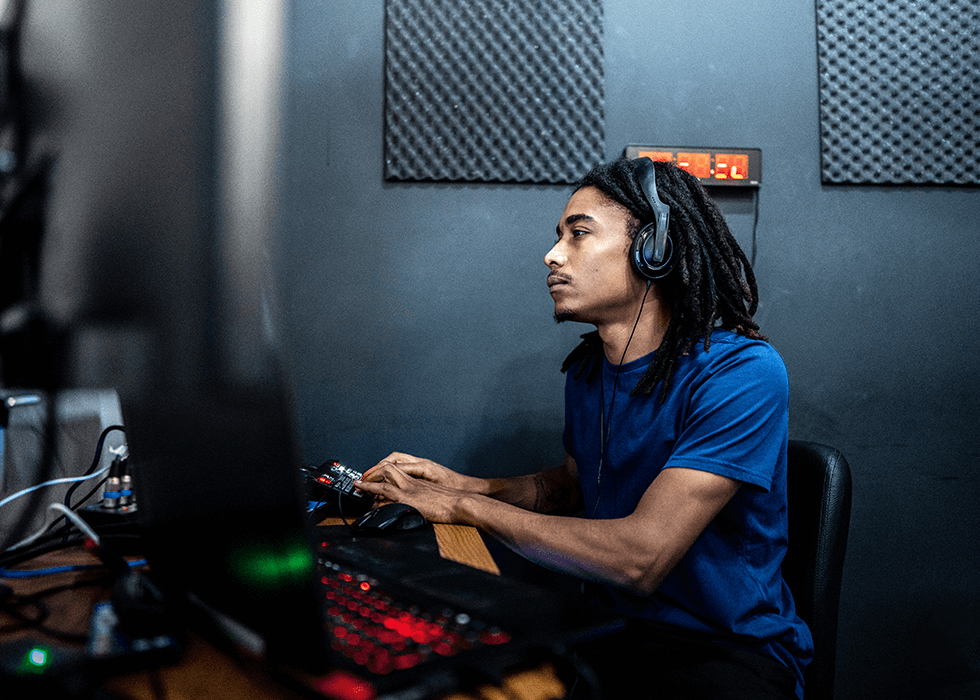 Audio engineer wearing headphones at a desk