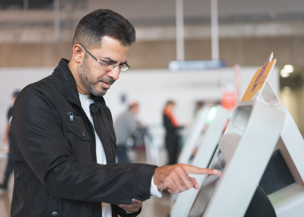 man looking at information screen at airport