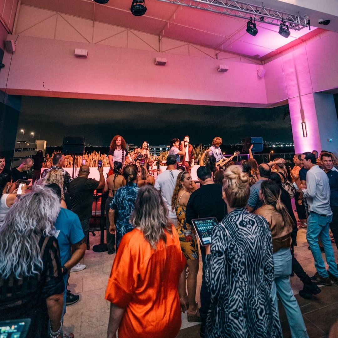 Vibrant nightlife scene at Rooftop Live Miami, with a crowd enjoying live music under colorful lights.