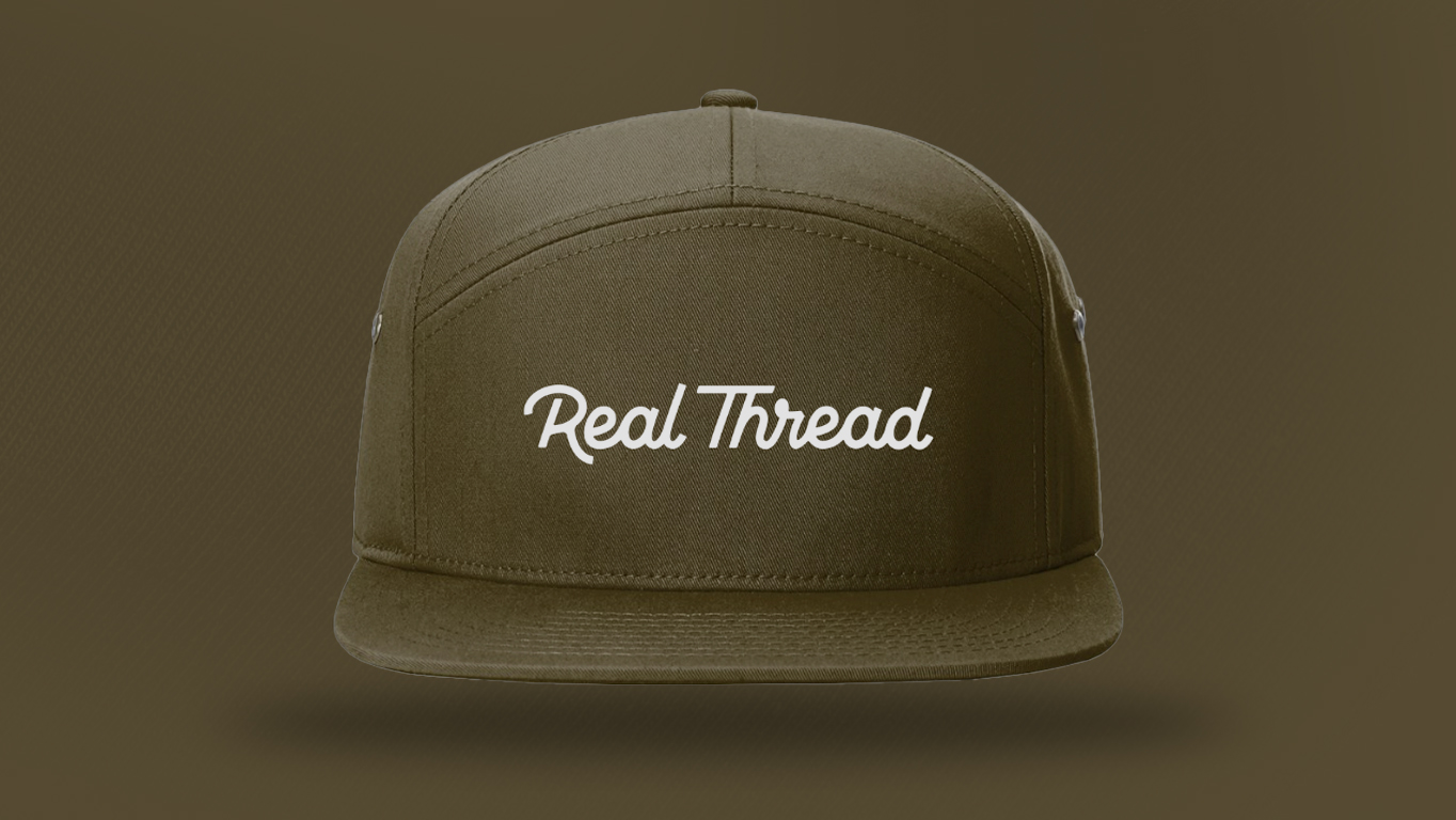 A olive green hat with real thread on it