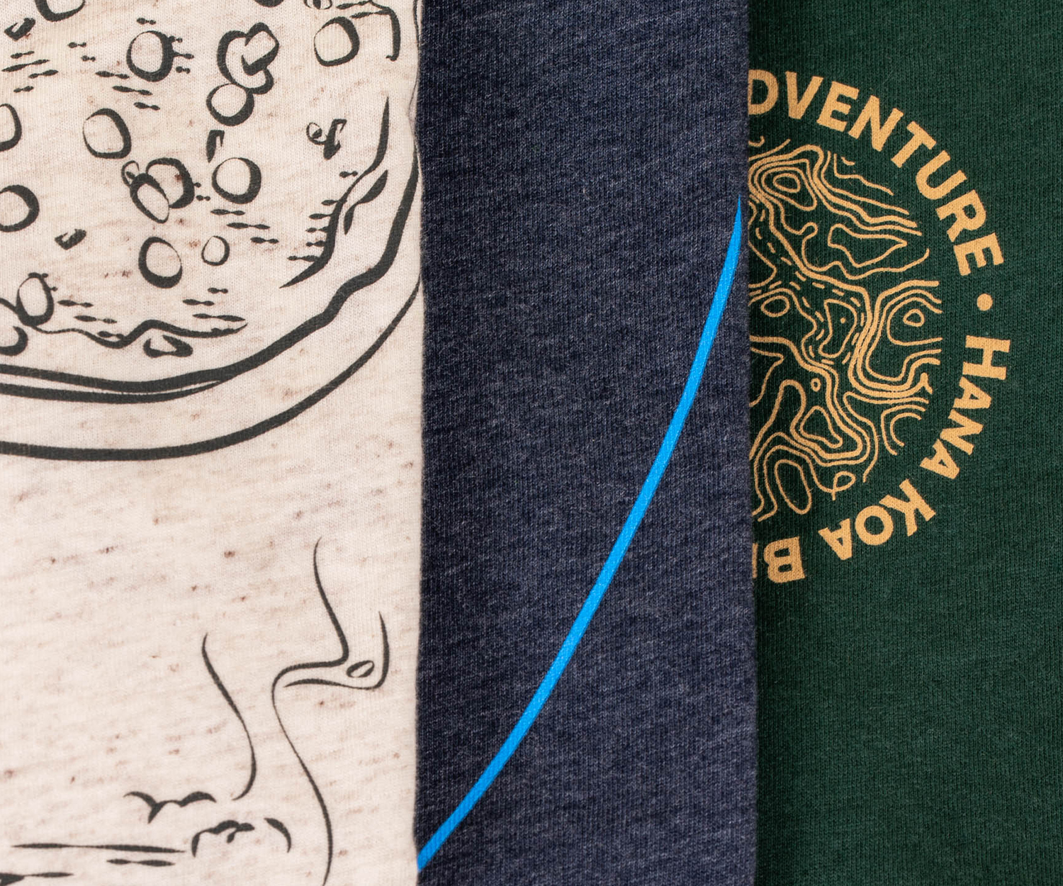 close up of three shirts, tan tri-blend, navy, and dark green