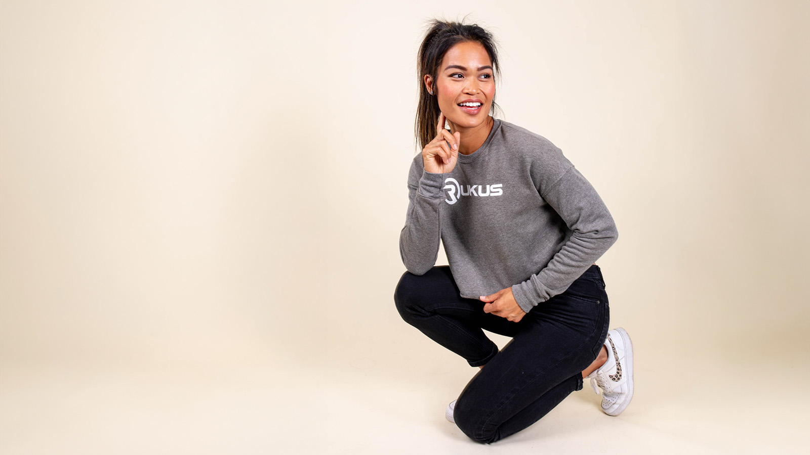 girl kneeling with a sweatshirt on it 
