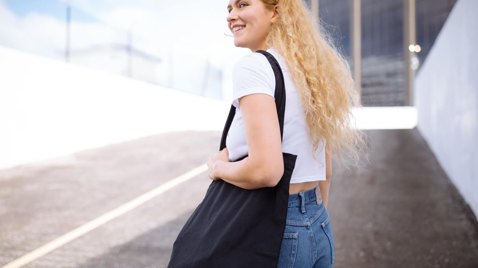 girl holding a black tote bag