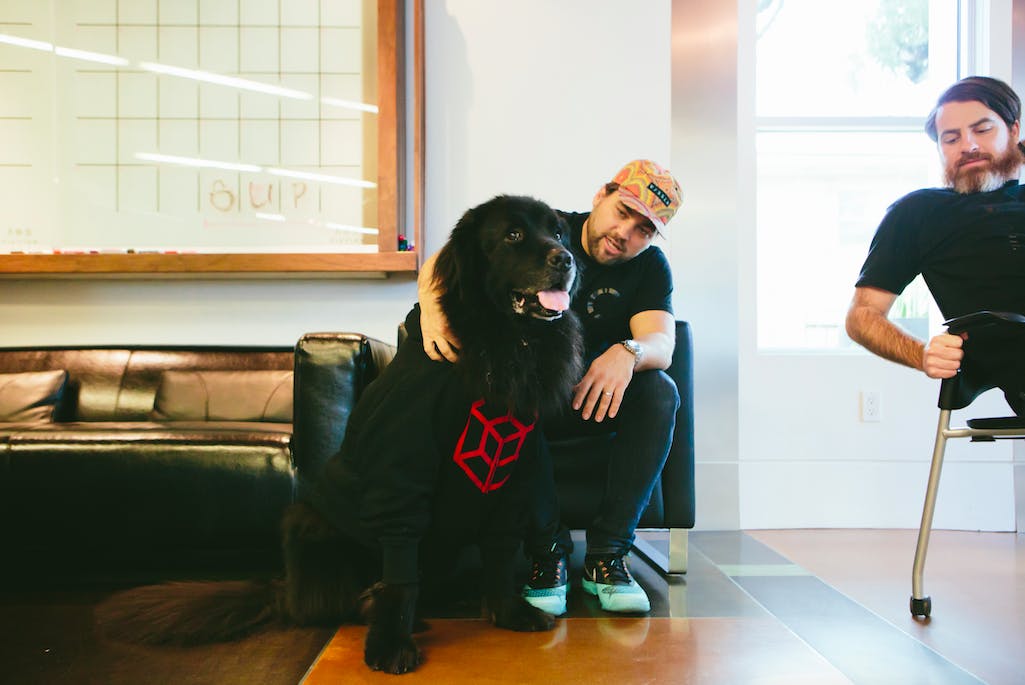 two people with a black dog