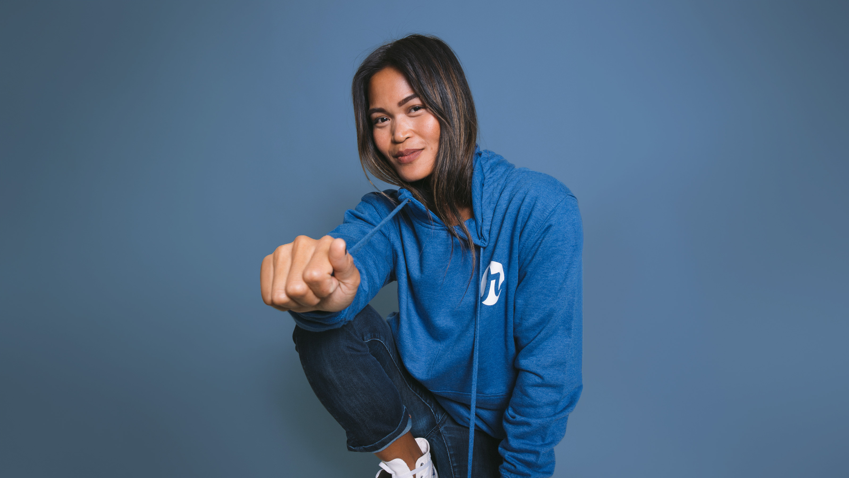 women kneeling with a blue hoodie on