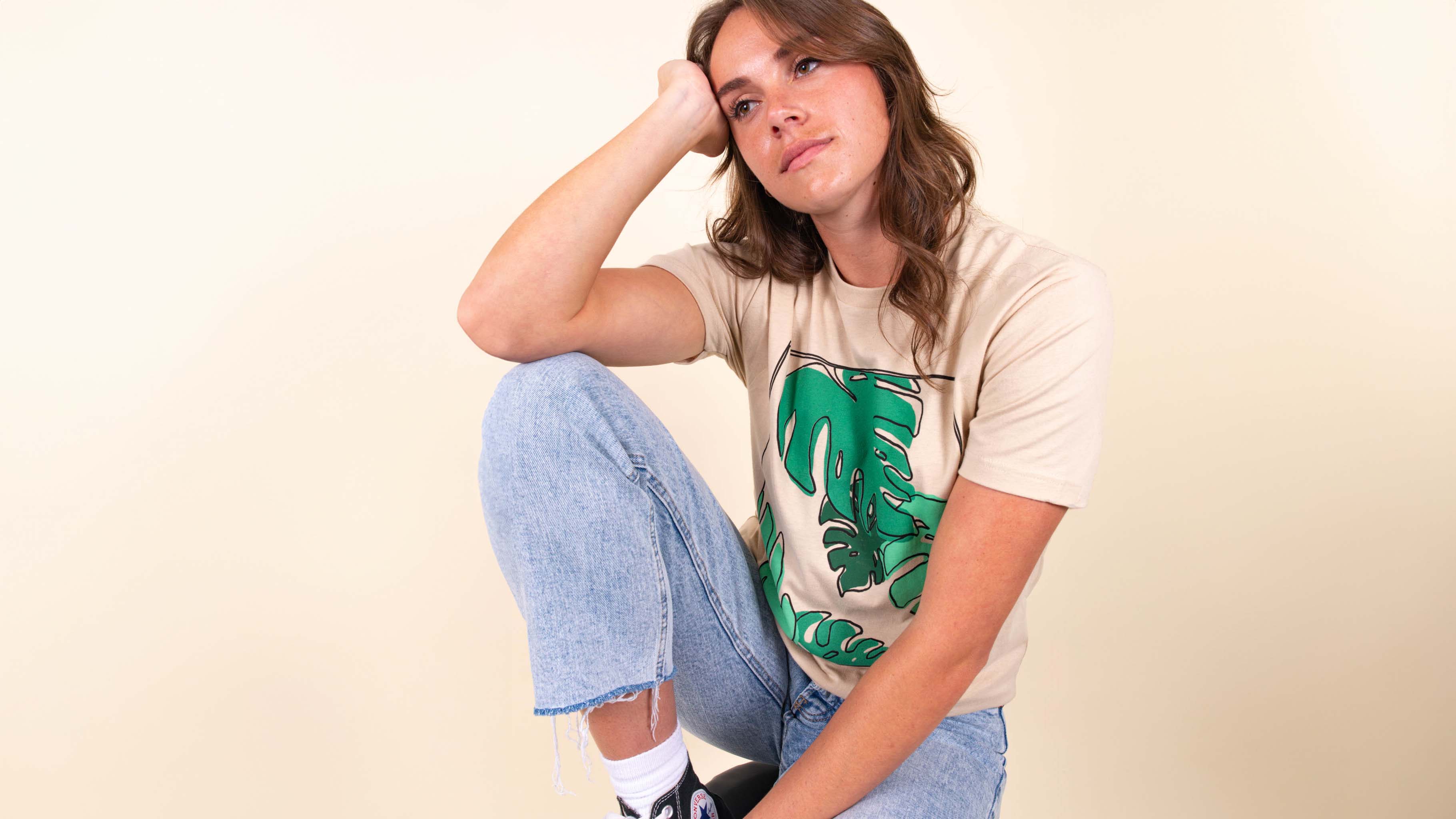women kneeling wearing a tan t-shirt