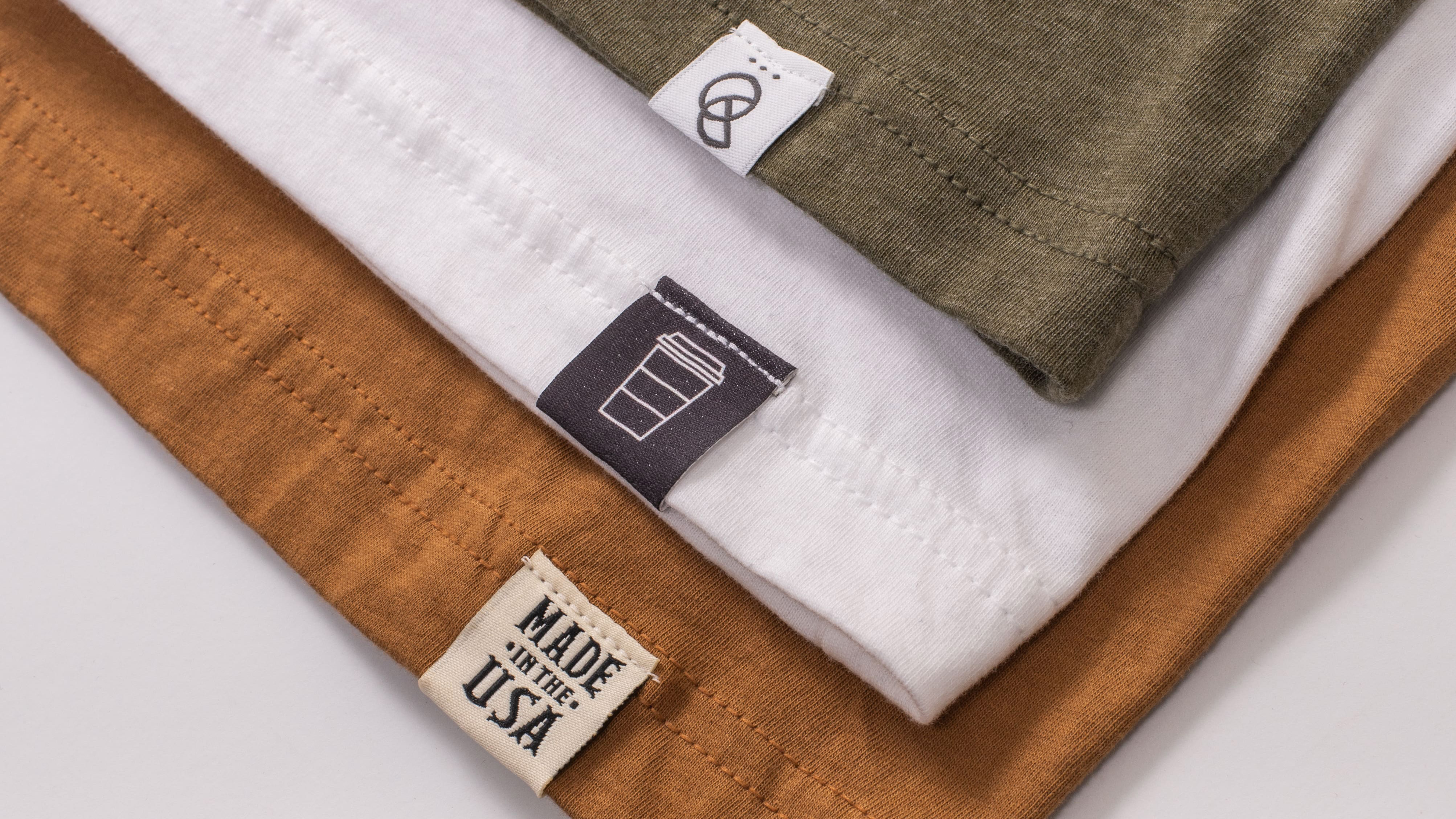 close up of three t-shirt with hem tags