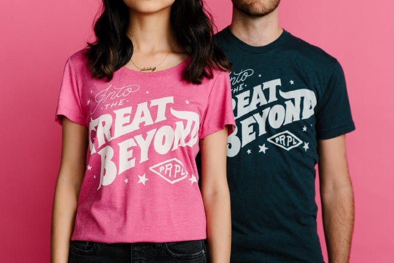 man and women posing in front of a pink background