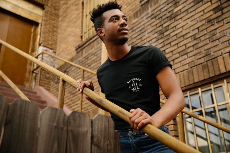 guy on stairs wearing a black screen printed t-shirt