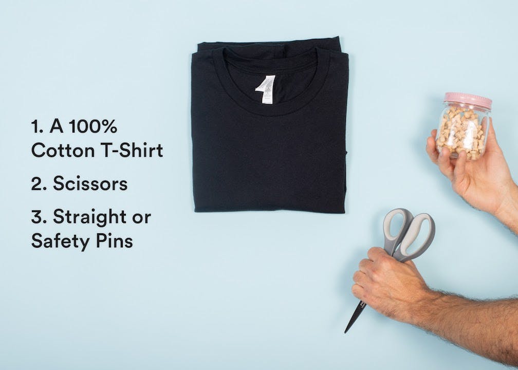 black shirt with man\'s arms holding scissors and pins 