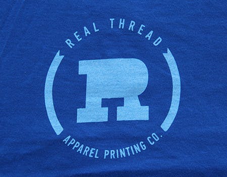 old real thread logo on blue fabric
