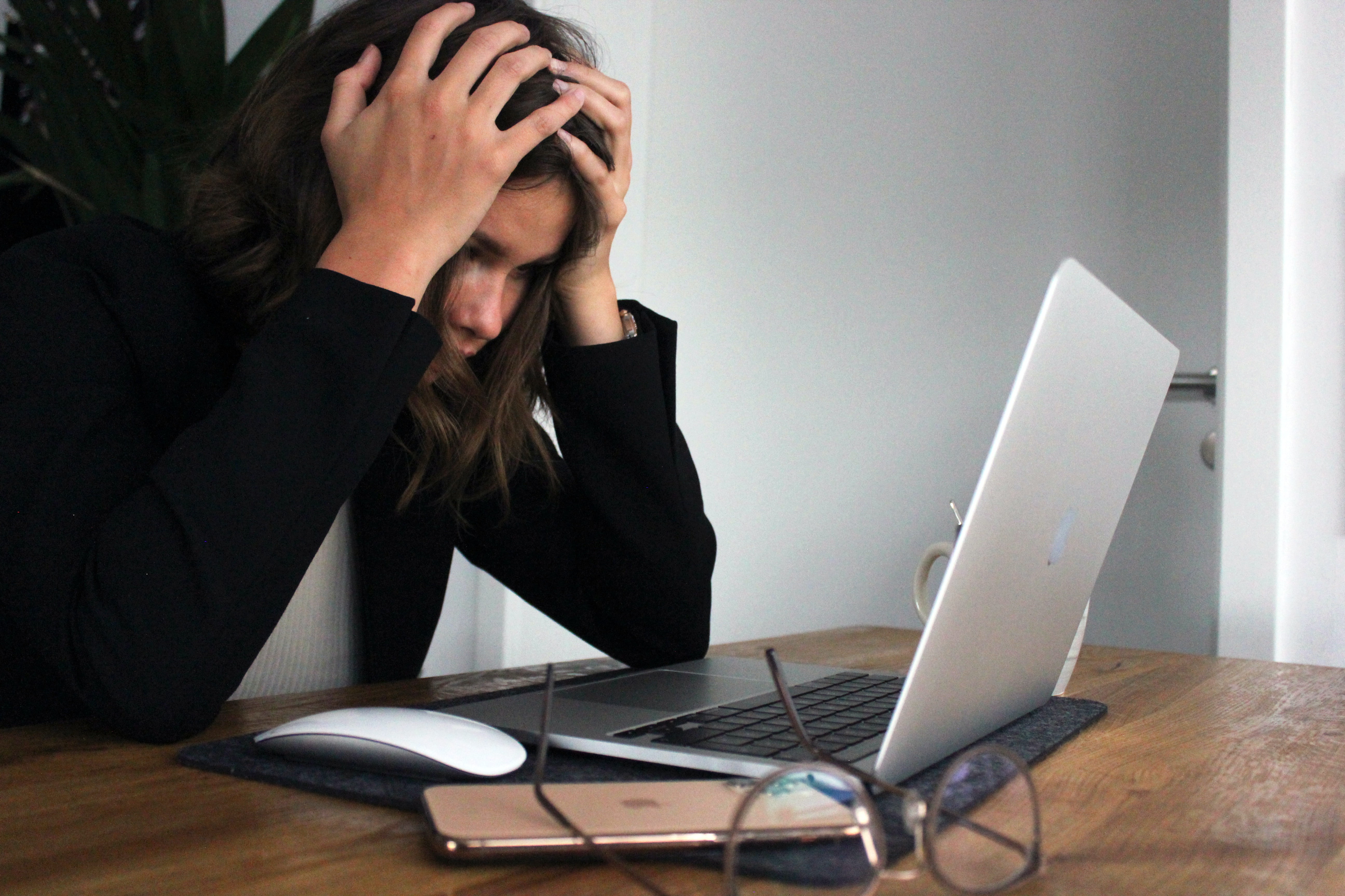 Photo of frustrated person looking at their laptop screen.