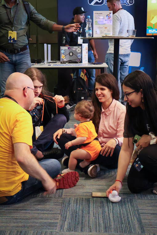 two women, two men in a circle with a baby in the center of attention