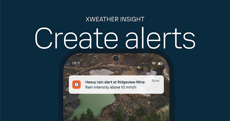 A heavy rain alert on a phone over with a photo of a partially flooded open cast mine.
