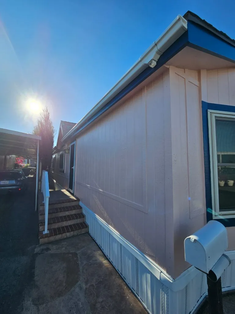 Mobile home after painting — white and blue trim complete